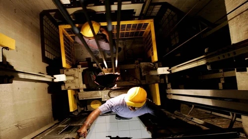 Asansör kuyusunda bakım yapan teknisyen